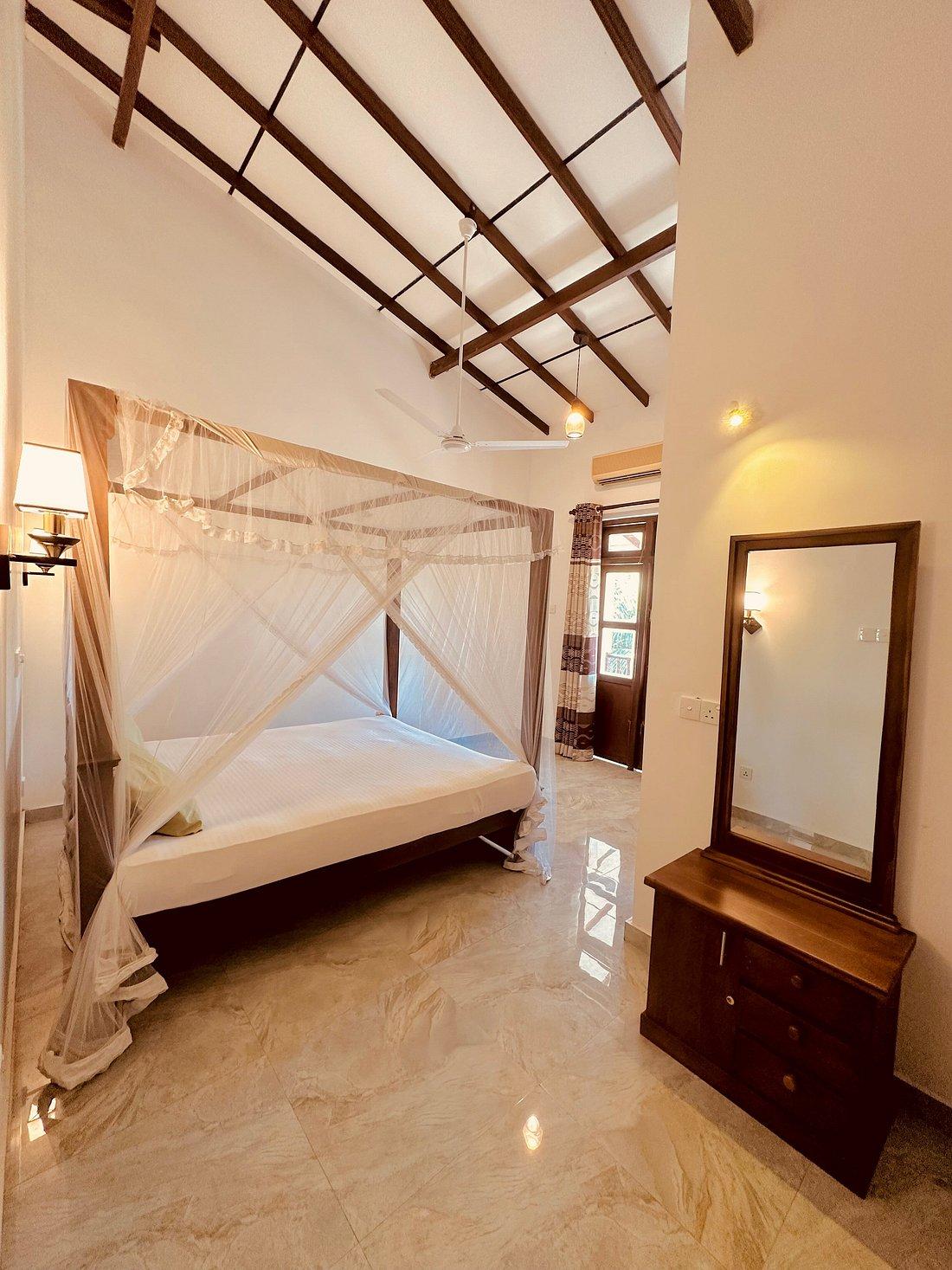 High-ceiling canopy bedroom at Riverwood Villa